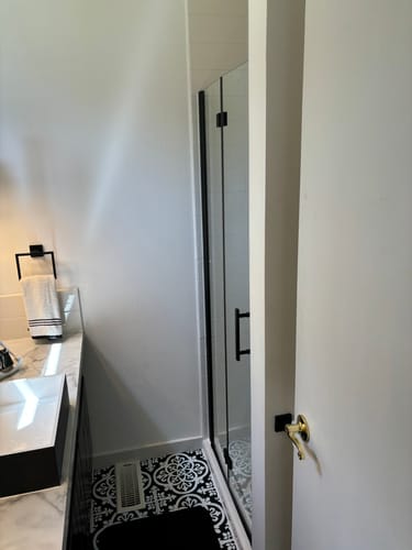 Customer photo review of SUNNY SHOWER 1/4 inch Bifold Shower Door with Semi-Frameless Clear Tempered Glass, Black Finish / Chrome Finish