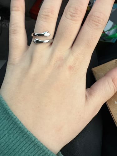 A customer's hand wearing the beautiful silver Hug Ring on their index finger.