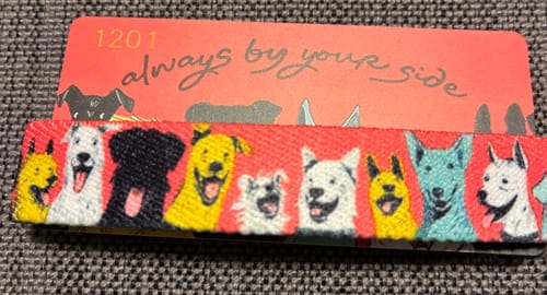 Close-up of a reviewer's Always By Your Side Bracelet, showing a colorful pattern with many happy dogs.