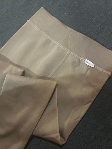 Photo d'un client montrant le collant polaire LEGGS plié, avec un gros plan sur la ceinture large et l'étiquette de la marque.