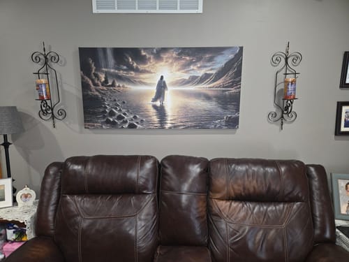 Customer's Walking on Water wall art displayed above a brown leather couch on a living room wall.