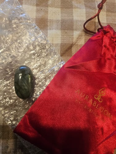 Reviewer's dark, polished monthly crystal shown with its red satin pouch and bubble wrap packaging.