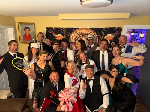 Customers in fun 1920s costumes posing for a group photo during the Murder Mystery Dinner Party Game.