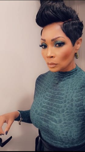 Reviewer in a close-up photo wearing the teal, printed Naked Print Mock Neck Top.