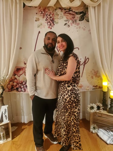 Customer wearing the leopard print Tulane Satin Midi Dress while posing with a partner at an event.