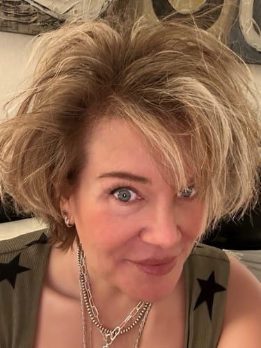 A close-up of the reviewer's face, showing her clear skin after using the Glov Micro Infusion System.