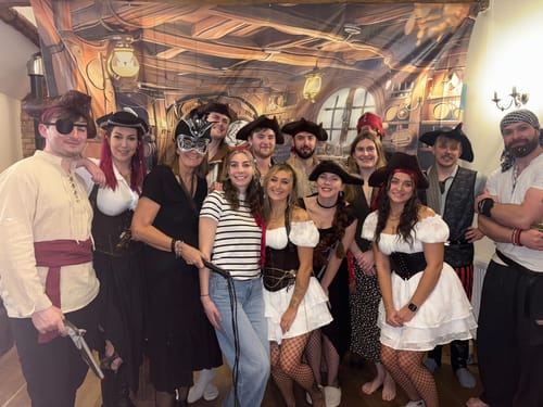 Customers in pirate costumes posing for a group photo during the Pirate Murder Mystery Host Your Own Game Kit party.