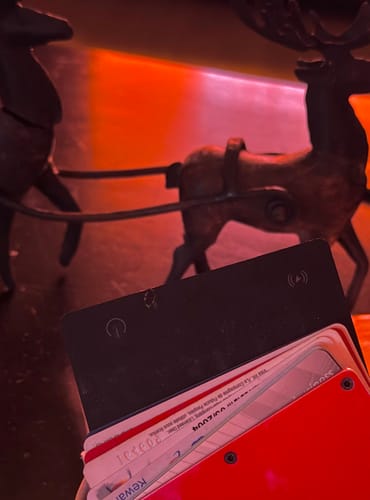 Close-up of a customer's black SPOTMINDERS Tracking Card inside a modern card wallet.