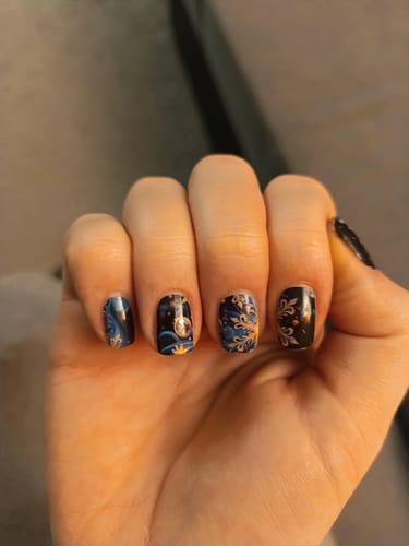 Kundin zeigt ihre kunstvolle Maniküre mit den Sunset Snow Nagelfolien in verschiedenen Designs.
