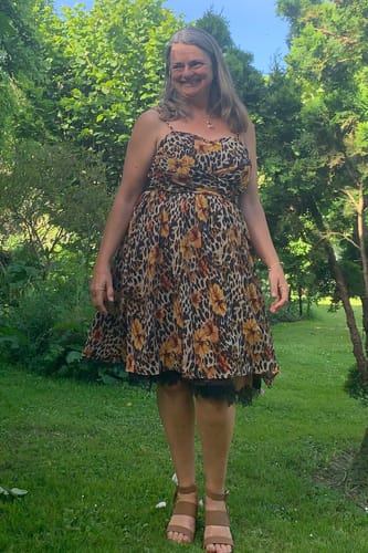 Reviewer standing outdoors in the flowy 1950s Slip Dress, showing its leopard sunflower print and black lace hem.