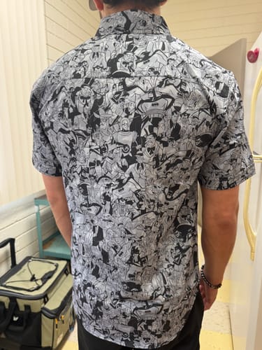 Customer seen from the back wearing the gray and black Batman "Bat Noir" shirt, showing the detailed character pattern.