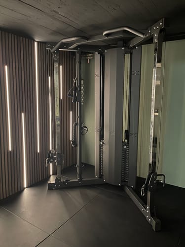 Kundenfoto der aufgebauten X-Five Low Kabelzugstation in einem modernen, dunklen Homegym.