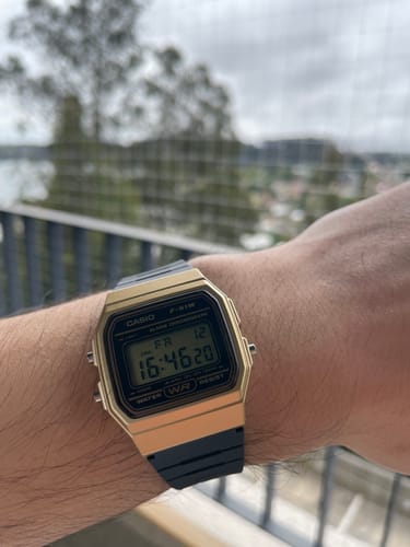 Reseñador luciendo su reloj Casio Vintage F-91WM-9ADF dorado y negro en la muñeca.