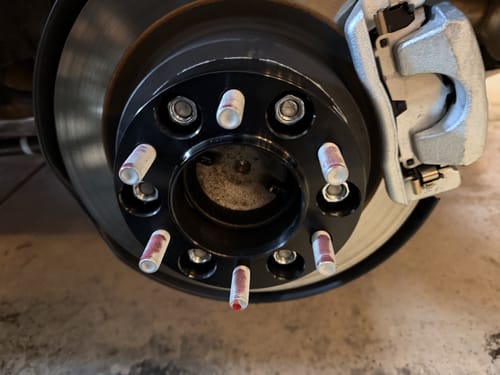 Customer's black 1.5 inch Hubcentric Wheel Spacer installed on a wheel hub with thread locker on the studs.
