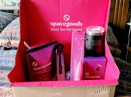 Customer's Rainbow Dust starter kit unboxed, showing the powder, pink whisk, and travel mug in a branded box.