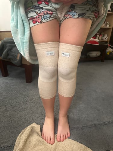 Reviewer wearing the Premium Bamboo Knee Sleeves on both knees indoors.