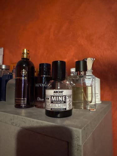 Il profumo ARCHÉ di un cliente su un mobiletto, in mezzo ad altre fragranze.