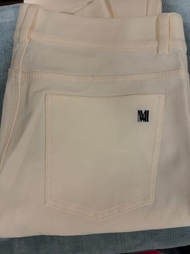 Reviewer's close-up of the Daria '90s Jean in Tusk, showing the black embroidered logo on the back pocket.