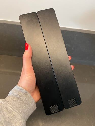 Reviewer holding the two sleek, black Weekly AM-PM Vitamin Cases side-by-side.