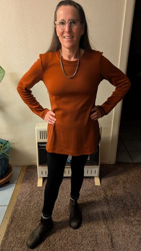 Reviewer wearing the long-sleeved Blair Tunic in Maple Leaf color with black leggings.