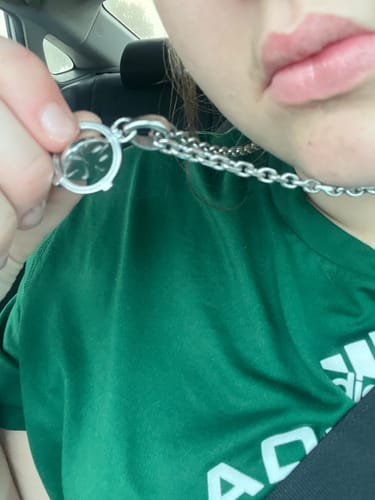 Close-up of a reviewer holding the clasp of their silver 4MM Mini Aries Chain around their neck.