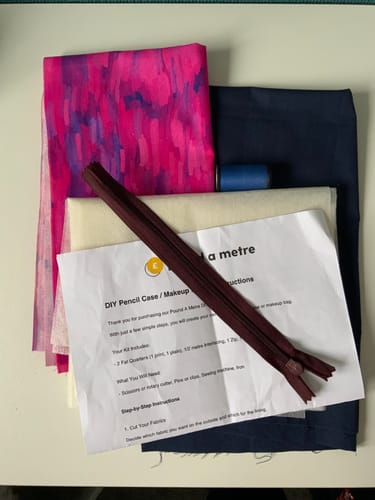 Customer's DIY Bag Bundle contents, including patterned fabric, thread, a zip, and printed instructions.