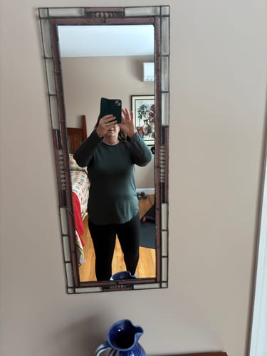 Customer taking a mirror selfie wearing the relaxed-fit Blair Tunic in Forest with black leggings.