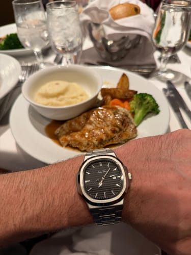 Customer wearing the Lucky Fours® Caspian watch on their wrist while sitting at a dinner table with a meal.