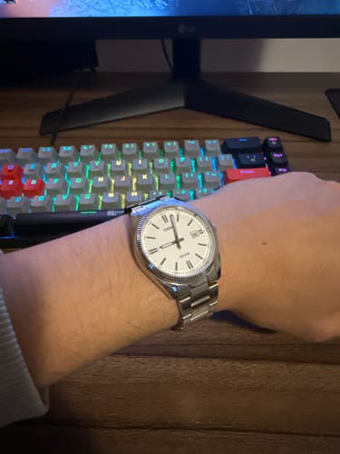 Cliente mostrando su reloj Casio Análogo con esfera blanca en su delgada muñeca.