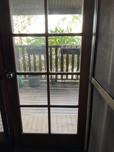 Customer shows a glass door pane on the right cleaned with KoalaCloth LITE, next to an uncleaned pane on the left.
