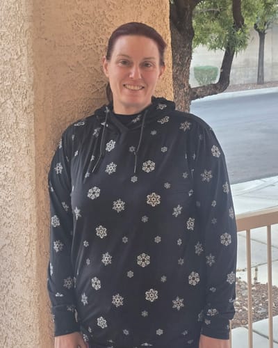 Reviewer smiling while wearing the black Star Wars 'Happy Hothidays' Performance Hoodie with a snowflake pattern.
