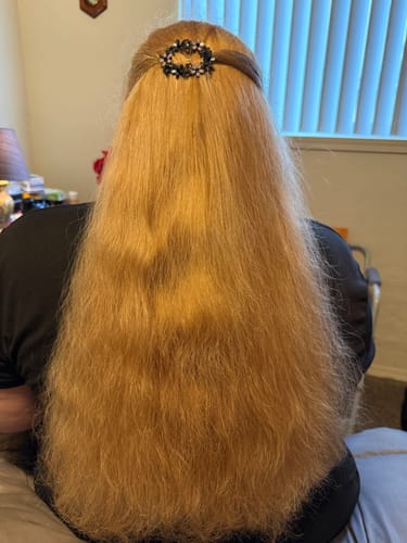 Reviewer from behind showing their long, golden-blonde hair after using the hair dye shampoo.