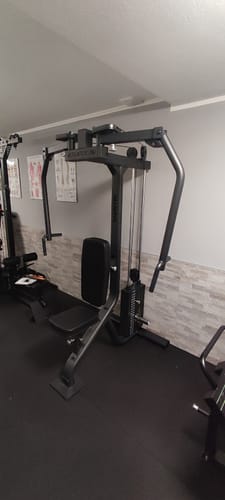 Die komplett montierte Mantis Butterfly Maschine eines Kunden, aufgestellt in einem Fitnessraum mit schwarzen Bodenmatten.