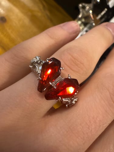Customer wearing the PROMISE RING with two glowing red coffin-shaped gems on their finger.
