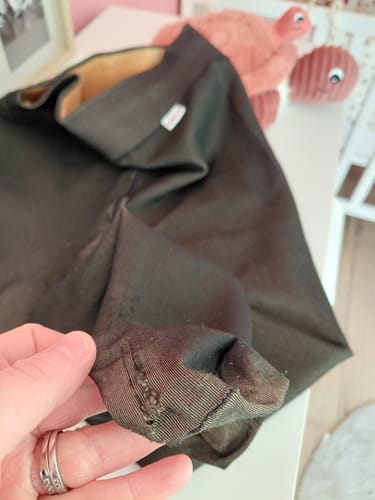 Gros plan d'un client montrant le tissu du collant polaire noir qui a bouloché et est abîmé à la cheville.