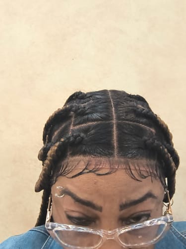 Close-up: Reviewer showing the neat, box-parted scalp of their Jumbo Knotless Braid wig.