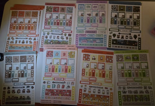Reviewer's collection of colorful Hobonichi Weeks sticker kits, including the Autumn Bunnies theme.
