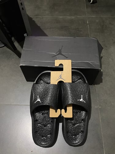 Customer's new black Jordan Franchise Shower Slides with textured straps displayed in front of the shoebox.