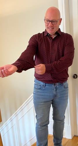 Client remontant la manche de sa chemise rouge NELUMBO pour montrer l'ajustement.