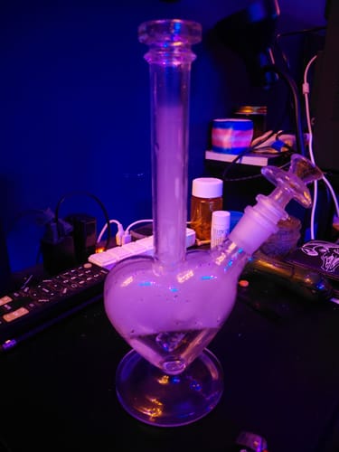 Reviewer's Perfect Heart Bong on a desk, its heart chamber filled with thick smoke.