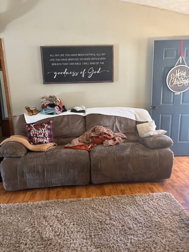 Customer's large Goodness Of God Faith Sign hung on a living room wall above a couch.