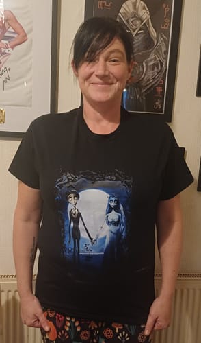 Customer wearing a black unisex t-shirt with a large graphic print of two cartoon characters.