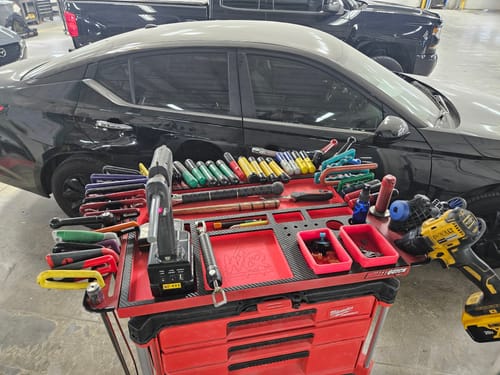 Customer's red Willey Quick Milwaukee Packout Top shown fully organized with various PDR tools in a workshop.