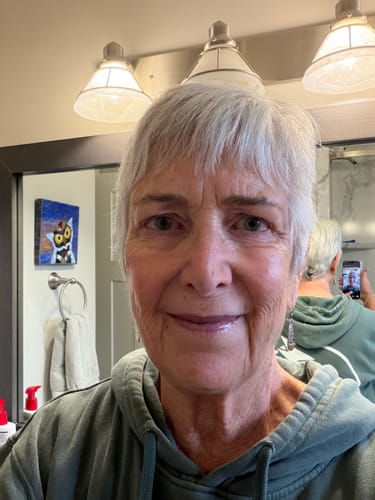 Customer showing her clear, smooth skin in a selfie after using Grass Fed Tallow & Honey Balm.