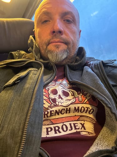 Client portant le T-shirt bordeaux de la COLLECTION EREDITA sous une veste ouverte.