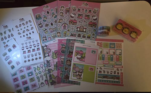 Reviewer's North Pole Theme Hobonichi Weeks Kit spread out on a desk, showing multiple colorful sticker sheets.