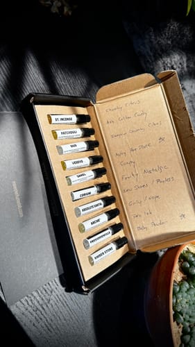 Il recensore mostra il Set campioni orientali e legnose aperto con le fiale di profumo e degli appunti sul coperchio.