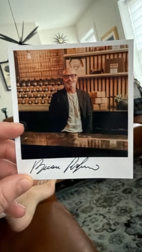 Cliente che mostra una fotografia autografata scattata in un negozio con i flaconi di Vesevo sugli scaffali.