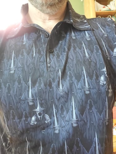 Reviewer wearing the 'Feel the Wraith' polo, showing a close-up of the dark pattern featuring Ringwraiths and the Witch-King.