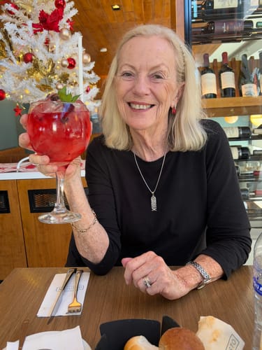 Customer who reviewed the KoalaCloth Mini smiling at a restaurant table.
